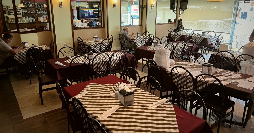 Comedor de Pekrys con las mesas vestidas y clientes almorzando al mediodía